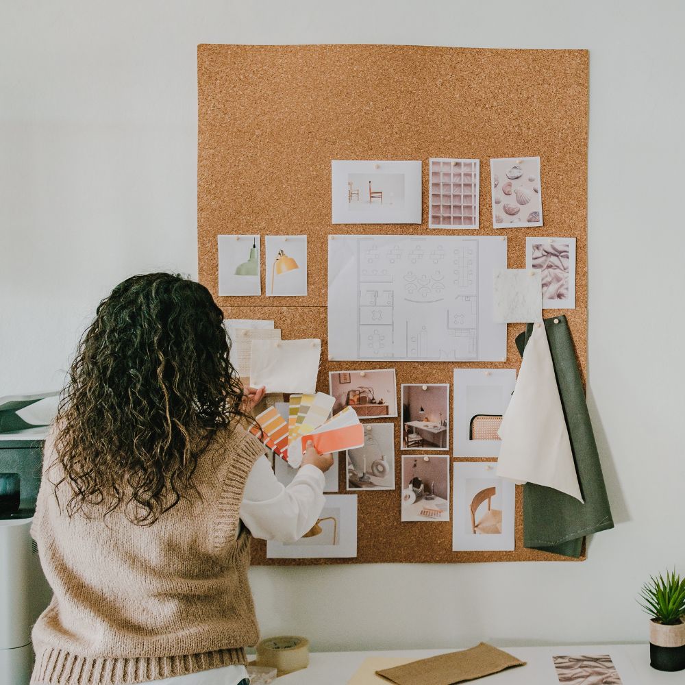 woman creating a vision board on a cork board